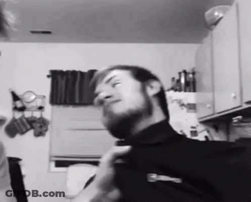 Bearded Man Adjusting Tie In Kitchen GIF