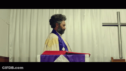 Bearded Man Before White Curtain And Cross GIF