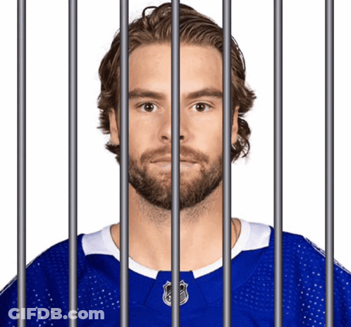 Bearded Man Behind Bars In Blue Jersey GIF