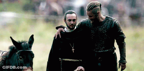 Bearded Man Beside Man With Cross Necklace GIF