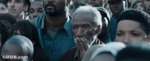 Bearded Man Covering Mouth In Crowd GIF