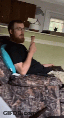 Bearded Man Eating In Chair GIF
