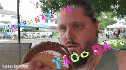 Bearded Man Eating Taco With National Taco Day Banner GIF