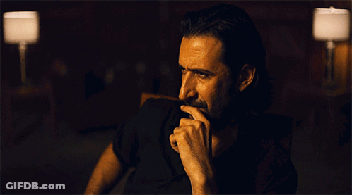 Bearded Man Hand On Chin In Dark Room GIF