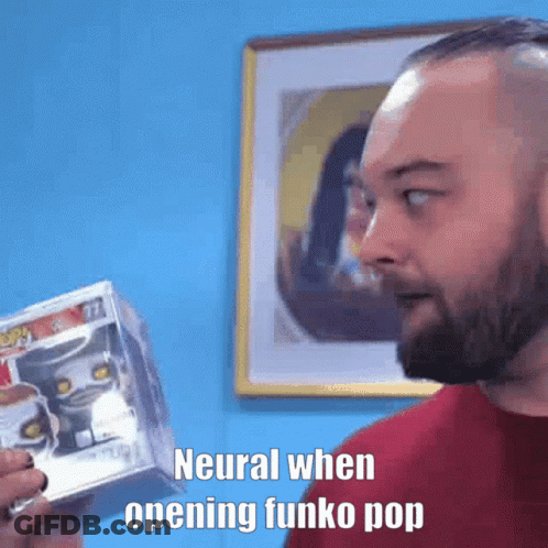 Bearded Man Holding Funko Pop In Front Of Blue Wall GIF