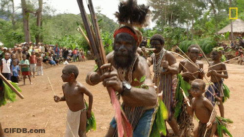 Bearded Man Holding Spear In Front Of Crowd GIF