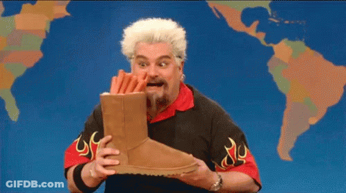 Bearded Man Holding Ugg Boots In Front Of World Map GIF