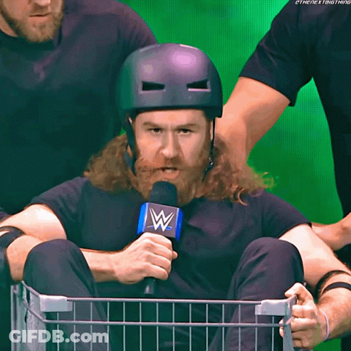 Bearded Man In Basket Holding Microphone With Letter W GIF