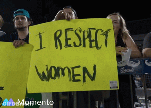 Bearded Man In Black Hat Smiling Next To Woman In Black Dress GIF