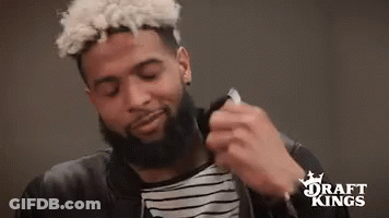 Bearded Man In Black Jacket And Striped Shirt Holding Necklace GIF