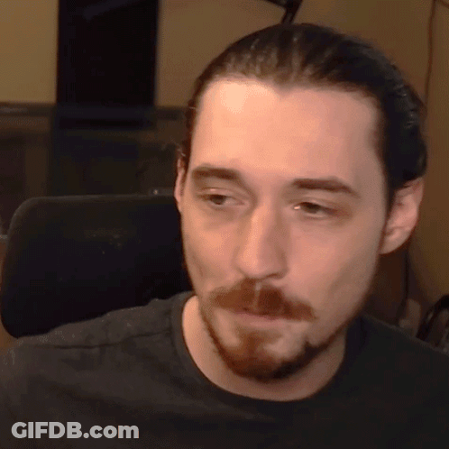 Bearded Man In Black Shirt Looking At Camera GIF