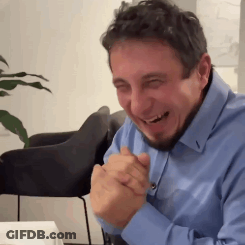 Bearded Man In Blue Shirt Laughing Hands Folded GIF