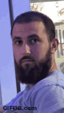Bearded Man In Blue Shirt Looking At Camera GIF