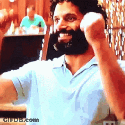 Bearded Man In Blue Shirt Talking On Cell Phone GIF