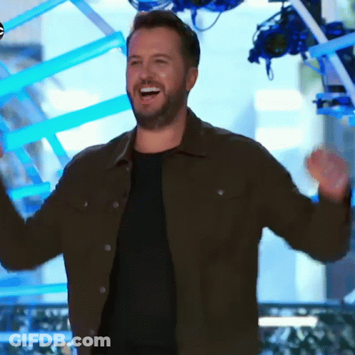 Bearded Man In Brown Jacket Smiling And Raising Arms GIF