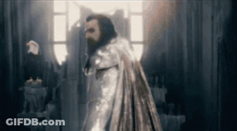 Bearded Man In Cape Standing In Dark Room GIF