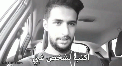 Bearded Man In Car With Arabic Writing On Face GIF