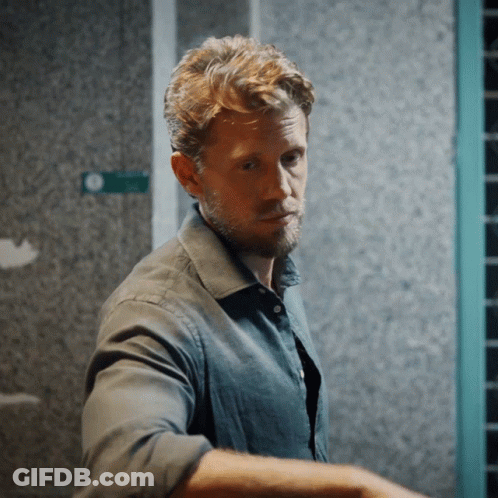 Bearded Man In Front Of Green Exit Sign GIF
