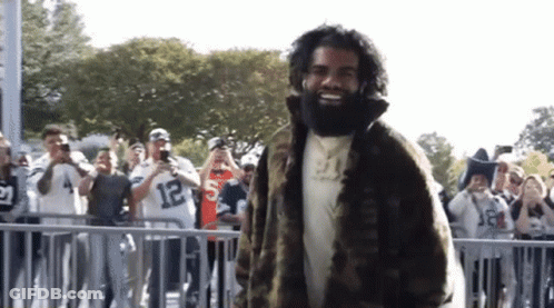 Bearded Man In Fur Coat Before Crowd GIF