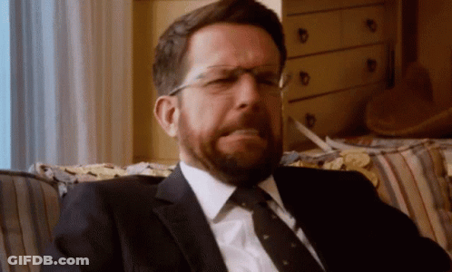 Bearded Man In Glasses And Suit On Couch GIF