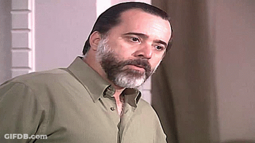 Bearded Man In Green Shirt Looking At Camera GIF