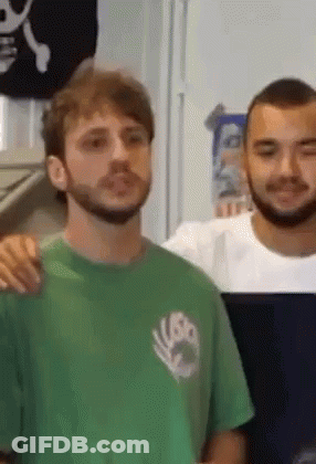 Bearded Man In Green Shirt Next To Man In White Shirt GIF