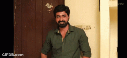Bearded Man In Green Shirt Standing In Front Of Door GIF