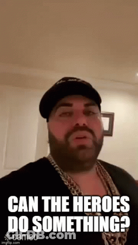 Bearded Man In Hat And Chains Saying Can The Heroes Do Something GIF