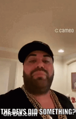 Bearded Man In Hat And Chains Says The Devs Did Something GIF