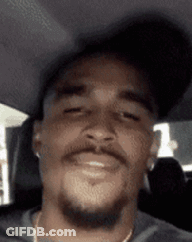 Bearded Man In Hat And Earbuds Smiling In Car GIF