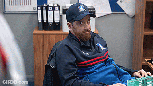Bearded Man In Hat And Jacket Sitting In Chair GIF