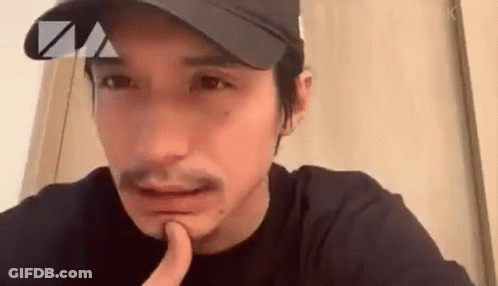 Bearded Man In Hat Holding Finger To Chin GIF