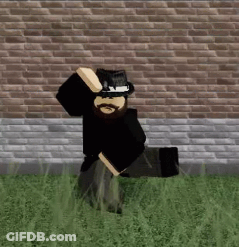 Bearded Man In Hat Kneeling By Brick Wall GIF