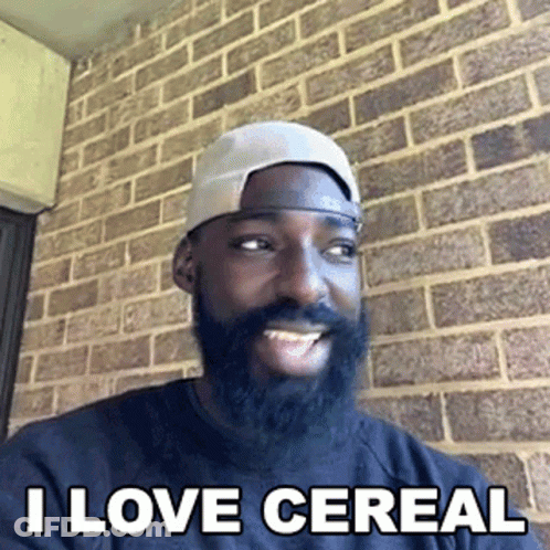 Bearded Man In Hat Smiling In Front Of Brick Wall GIF