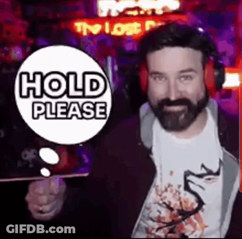 Bearded Man In Headphones With Hold Please Sign GIF