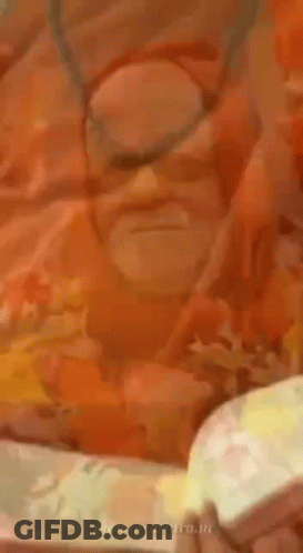 Bearded Man In Orange Robe And Necklace GIF