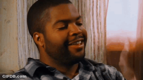 Bearded Man In Plaid Shirt Smiling On Couch GIF