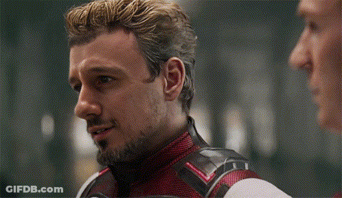 Bearded Man In Red And Black Suit Talking To Another Man GIF