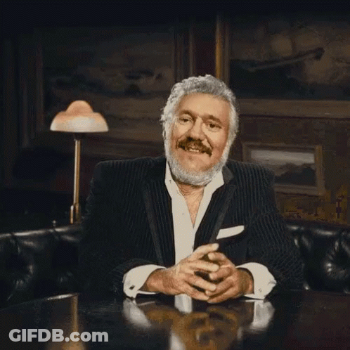Bearded Man In Suit Sitting With Folded Hands GIF