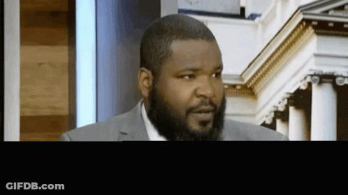 Bearded Man In Suit Sitting GIF