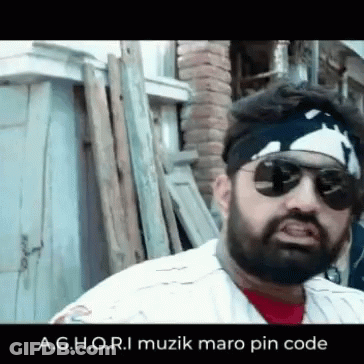 Bearded Man In Sunglasses And Bandana By Wood Pile GIF