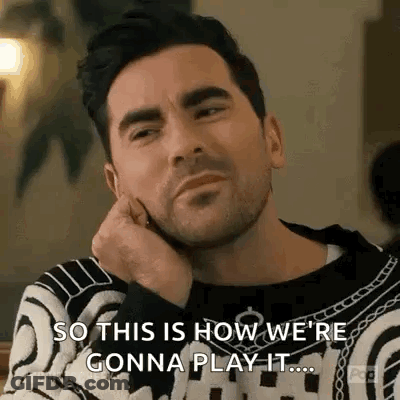 Bearded Man In Sweater Hand On Chin At Table GIF