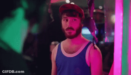 Bearded Man In Tank Top And Hat In Front Of Neon Sign GIF