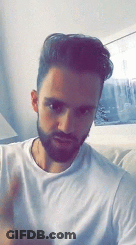 Bearded Man In White T-Shirt On Couch GIF