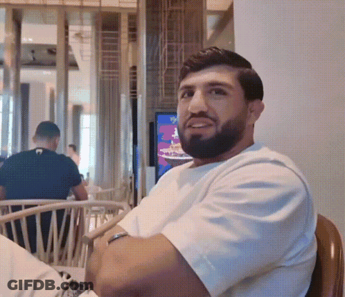 Bearded Man In White T-Shirt Sitting In Chair GIF