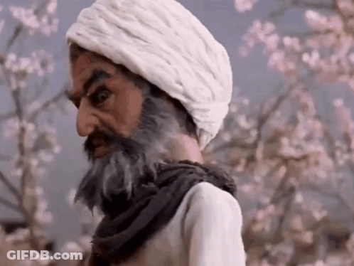 Bearded Man In White Turban Beside Flowering Tree GIF