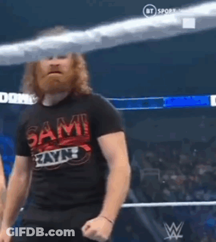 Bearded Man In Wrestling Ring In Sami Zayn Shirt GIF