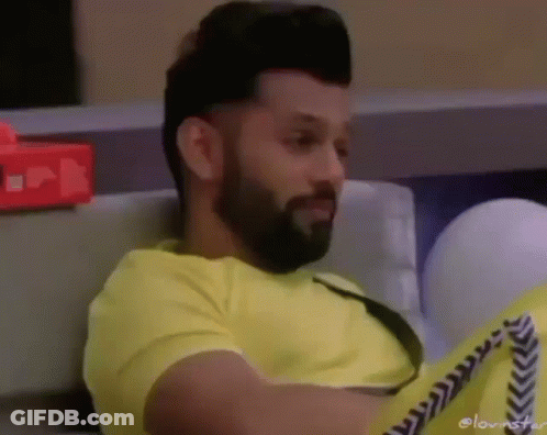Bearded Man In Yellow Shirt Sitting On Couch GIF