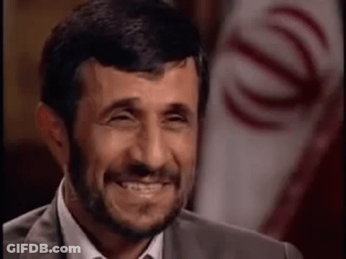 Bearded Man Laughing In Front Of Flag GIF