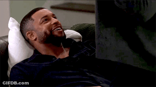 Bearded Man Laying On Couch Smiling GIF